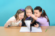 Three happy girls doing their school work