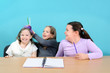 Happy school girls making jokes in classroom
