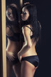 sexy woman in underwear standing next to a mirror