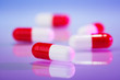 Red and white capsules (bolus) on violet, macro view medical con