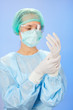 Young beautiful surgeon doctor (woman) before operation on blue