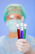 Medical test tube samples in doctor's hand on blue background Medical test tube samples in doctor's hand on blue background