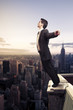 Photo: businessman standing on top of a building in NY city businessman standing on top of a building in NY city