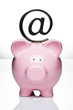 At symbol paperweight on top of a piggy bank