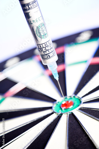 Photo: Syringes with 100 dollars inside, stuck in a dartboard Syringes with 100 dollars inside, stuck in a dartboard