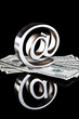 Foto: At symbol paperweight on a pile of 100 dollar bills At symbol paperweight on a pile of 100 dollar bills