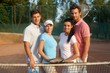 Young couples on tennis court smiling
