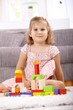 Photo: Smiling little girl building tower at home Smiling little girl building tower at home
