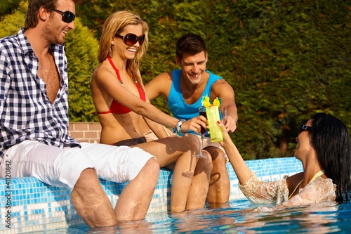 Photo: Young friends by swimming pool smiling Young friends by swimming pool smiling