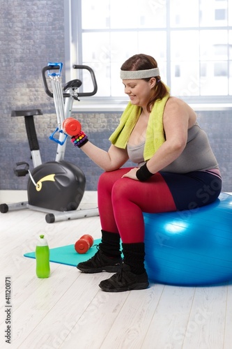 Photo: Plump woman exercising with dumbbells Plump woman exercising with dumbbells