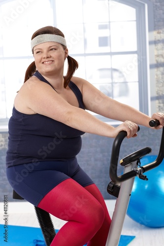 Photo: Fat woman on exercise bike Fat woman on exercise bike