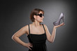 junge Frau mit Sonnenbrille präsentiert Schuh