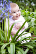 happy baby sat in bluebells