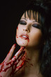 bloody vampire girl with delight on face on a black background