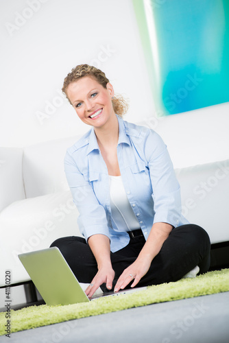 Photo: frau sitzt begeistert vor ihrem laptop frau sitzt begeistert vor ihrem laptop