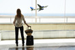 Girl at the airport window looking to the ocean