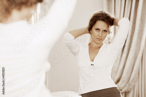 Photo: Beautiful woman looking in the mirror Beautiful woman looking in the mirror