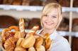 lächelnde bäckereiverkäuferin mit backwaren