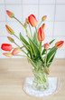 Vase mit einem Blumenstrauß roter Tulpen.