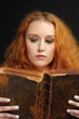 Photo: Young woman reading an old bible Young woman reading an old bible