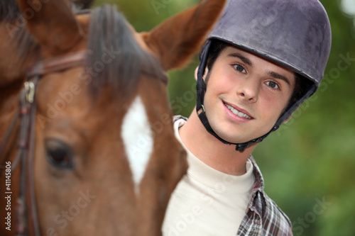 Photo: young man riding a horse young man riding a horse