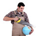 Carpenter sawing into globe
