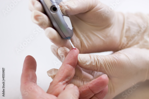 Foto: Altenpflegerin misst den Blutzuckerspiegel einer Patientin Altenpflegerin misst den Blutzuckerspiegel einer Patientin