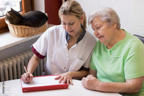 Photo: Altenpflegerin beim Hausbesuch einer Patientin Altenpflegerin beim Hausbesuch einer Patientin