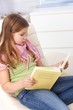 Little girls reading a book at home