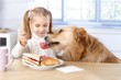 Little girl and dog having lunch together