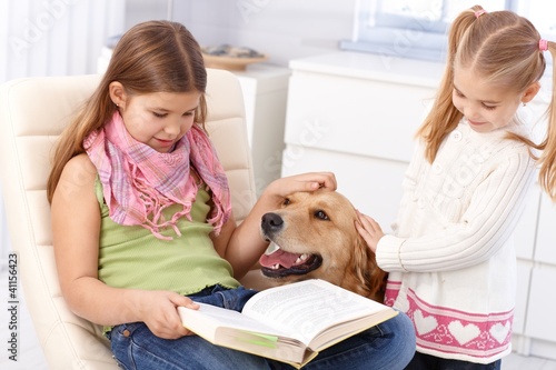 Photo: Little sisters with dog at home Little sisters with dog at home