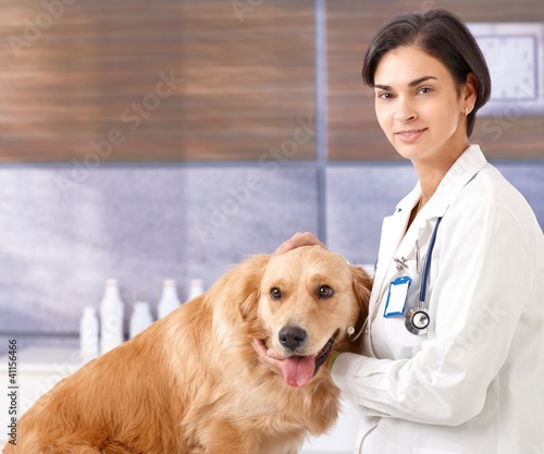Photo: Female vet with dog at clinic Female vet with dog at clinic