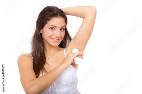 Photo: young woman putting on deodrant young woman putting on deodrant