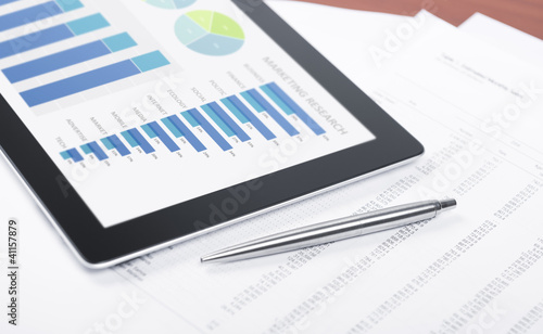 Photo: Modern workplace with success charts on digital tablet Modern workplace with success charts on digital tablet