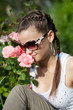Beautiful girl sniffs scent of roses