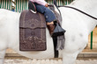 Detail of a little girl riding a horse on a spanish saddle