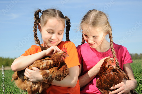 Photo: Two girls holding chickens Two girls holding chickens