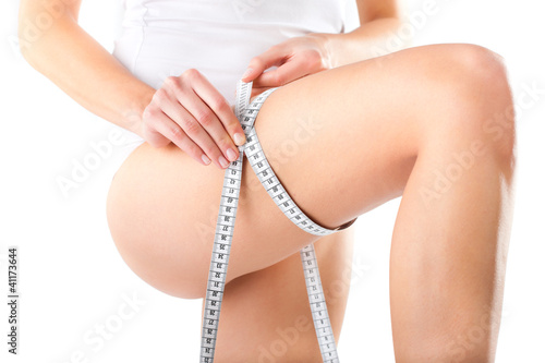Photo: Young woman measuring her thigh Young woman measuring her thigh