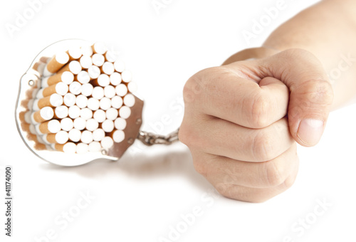 Photo: Cigarette and handcuffs isolateed on white Cigarette and handcuffs isolateed on white