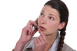 Doubtful woman talking on her mobile phone