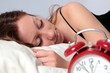 Frau mit Wecker schlafend