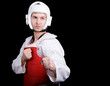 Young man inTaekwondo gear against black background Young man inTaekwondo gear against black background