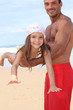 little girl lying down on father's arms on the beach little girl lying down on father's arms on the beach