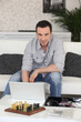 Man sat with laptop and chess board