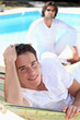Two men relaxing by poolside Two men relaxing by poolside