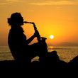 The silhouette of a female musician playing her saxophone