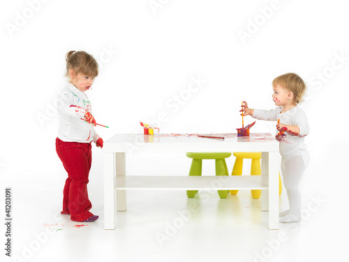 Photo: pretty baby girls painting in white studio pretty baby girls painting in white studio