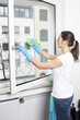 Frau putzt Fenster