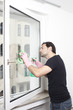 Mann putzt ein Fenster