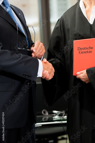 Foto: Anwältin mit Gesetzbuch und Mandant Anwältin mit Gesetzbuch und Mandant